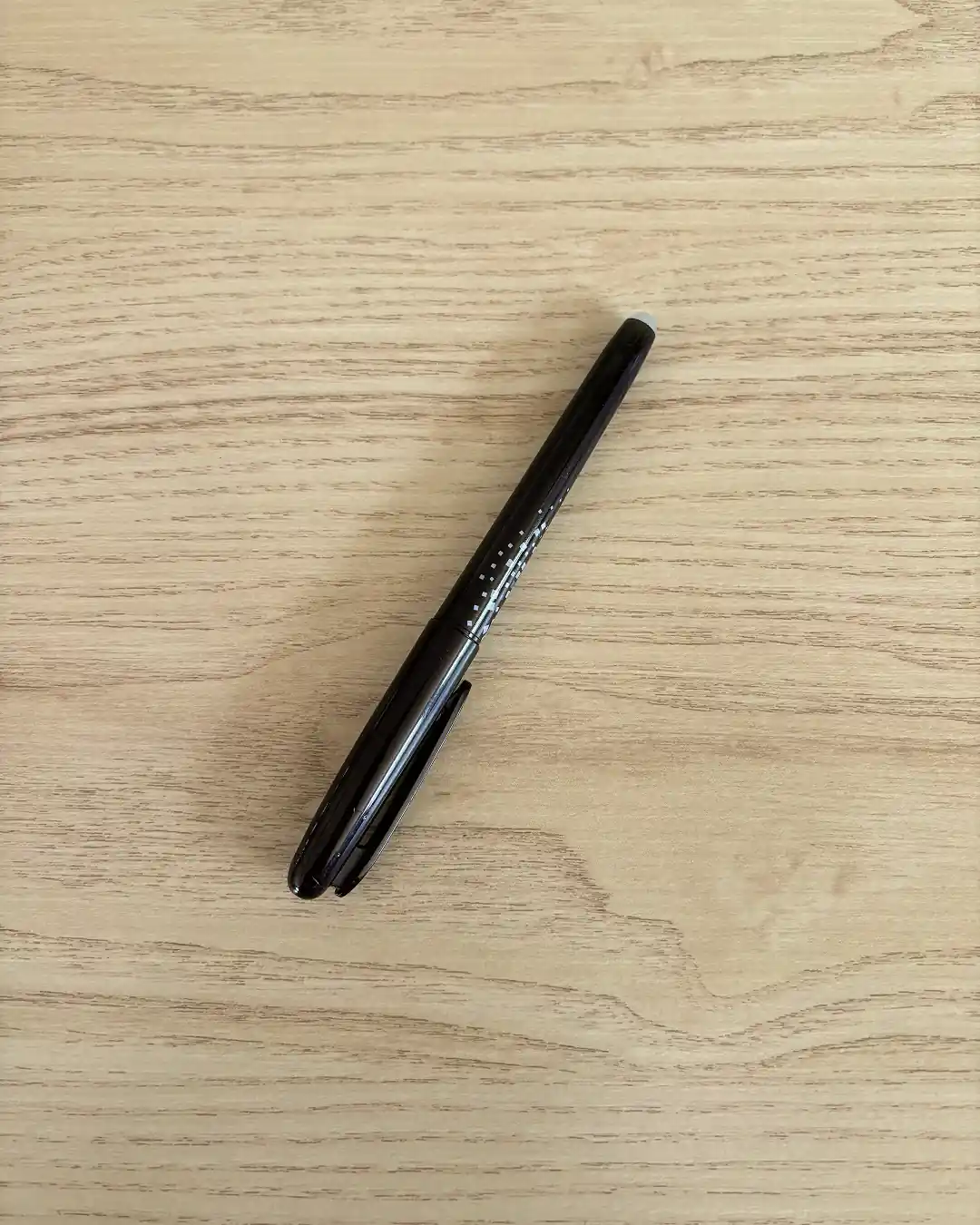 Stylo à encre friction et craie de couturière posés sur du tissu